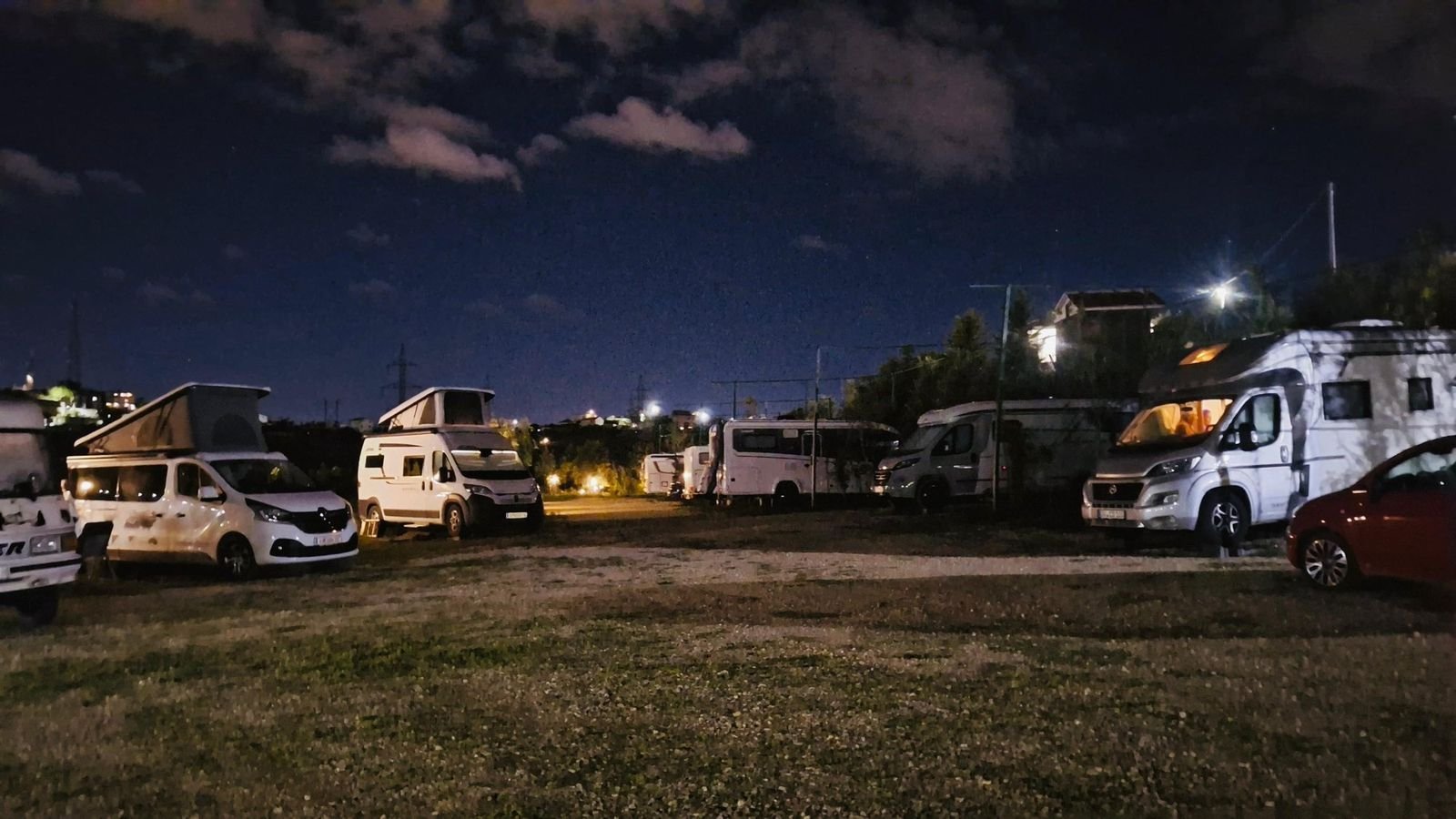 Campervans under the camp lights at night at Wonderful Camping