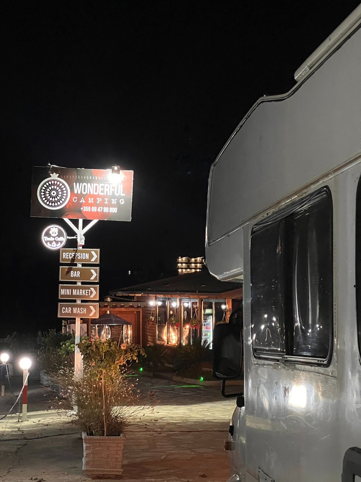 The Wonderful Camping sign lit up at night